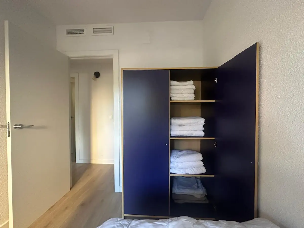 Open wardrobe with household linen and storage at San Blas Stay Alicante