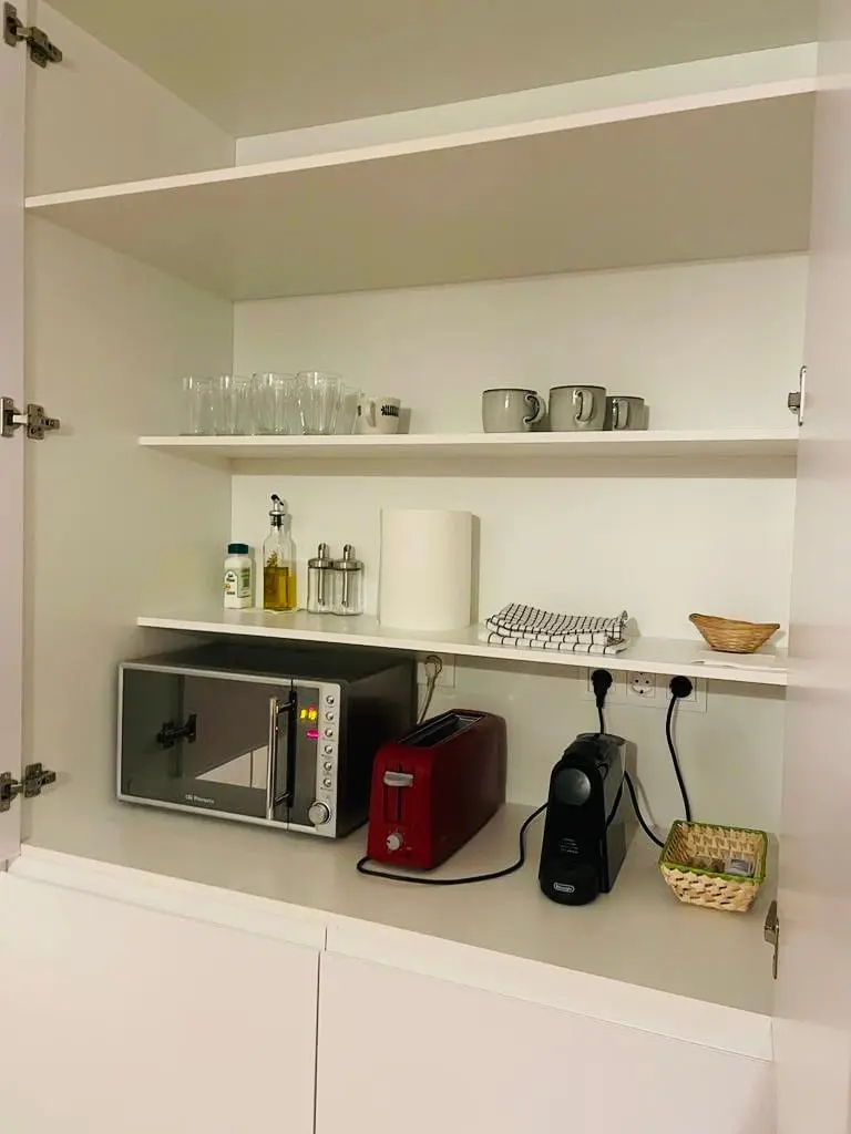 Kitchen shelving with microwave coffee maker and small appliances at San Blas Stay Alicante